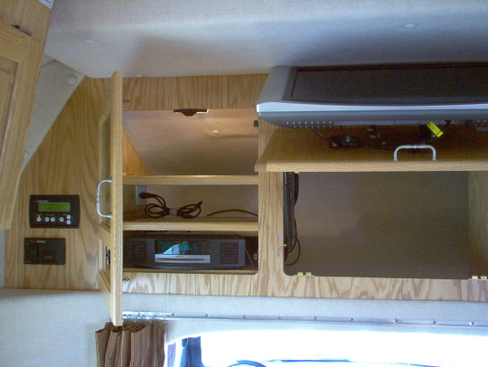Satellite tuner is behind satellite controller (black panel on left of photo). Receiver mounts on middle shelf behind smoked glass door. Switch is at back in center area behind TV.